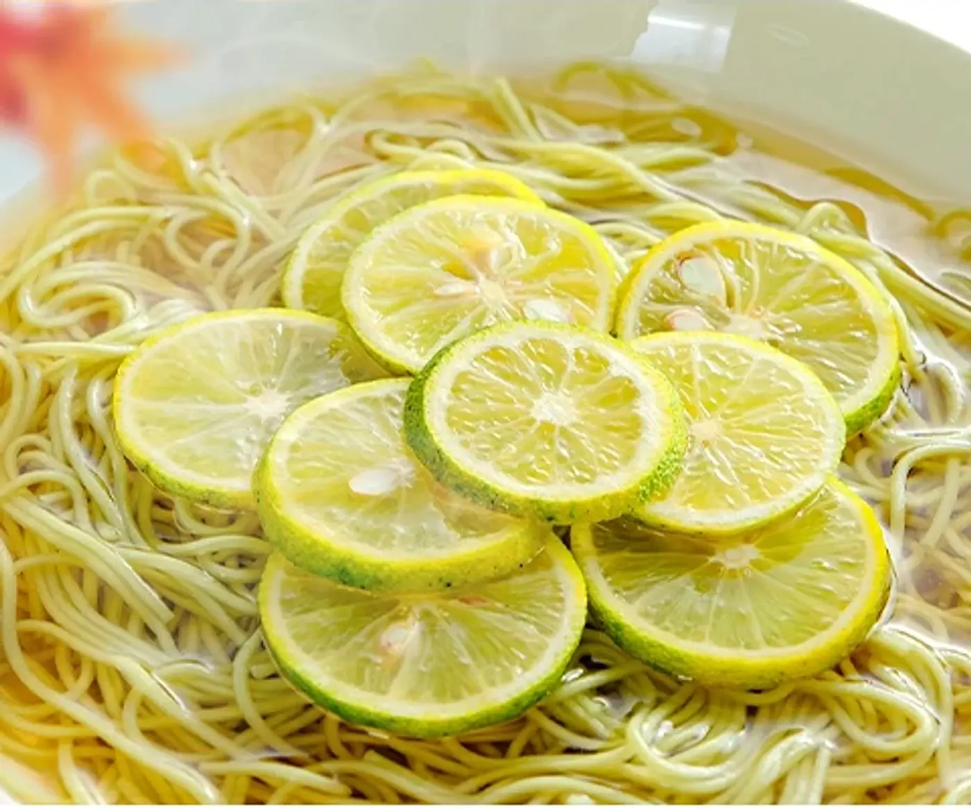 紅葉を背景に、すだちのスライスを浮かべた温かい出汁のすだち麺